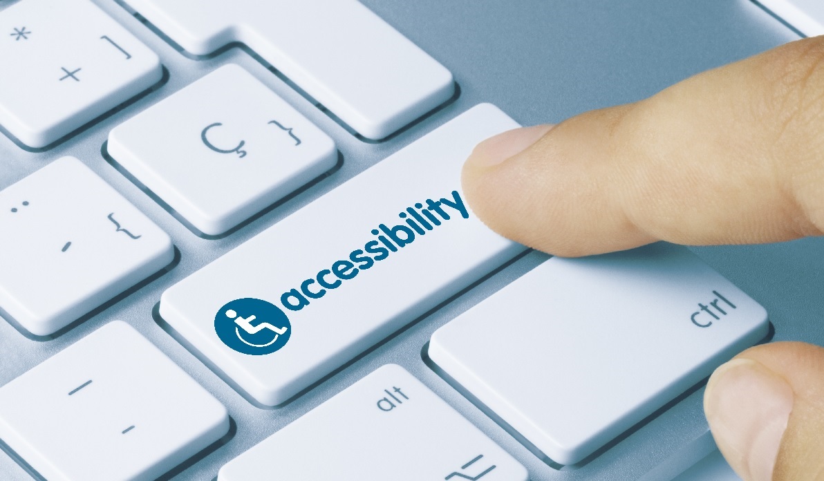 A finger presses an Accessibility key on a laptop